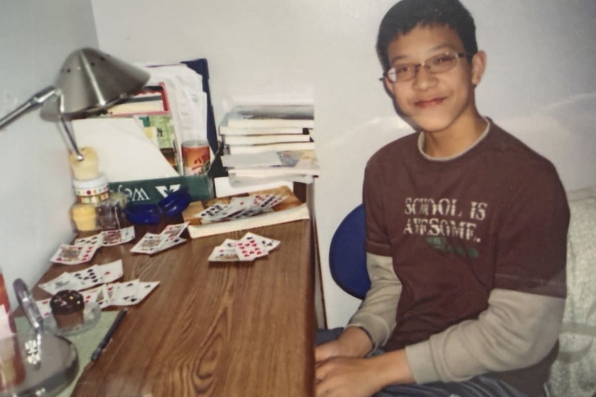 Ian as a boy at a desk with playing cards laid out