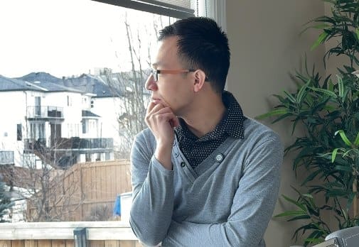 Ian sitting by a window, thinking
